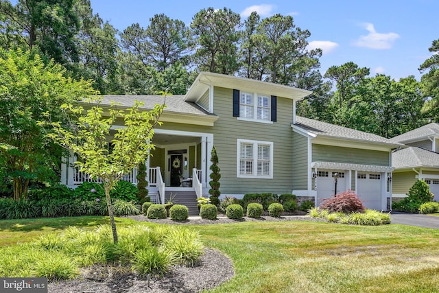 11742 Maid At Arms Ln, Berlin, MD 21811 - view of front of house featuring a front lawn, an attached garage, covered porch, driveway, and a shingled roof