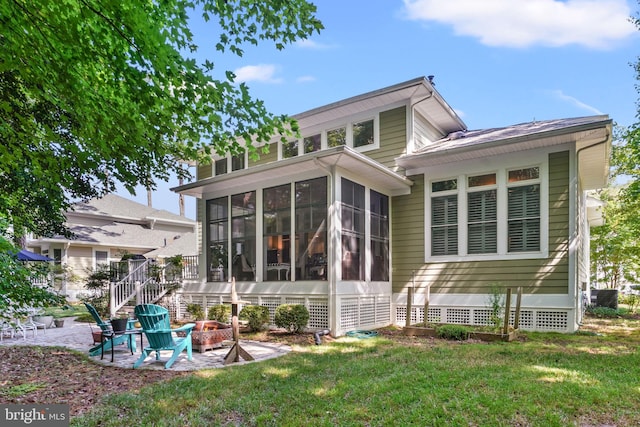 11742 Maid At Arms Ln, Berlin, MD 21811 - rear view of house with a sunroom, a lawn, a patio area, a fire pit, and central AC