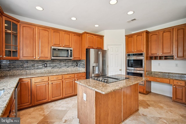 1624 Osprey Cir, Cambridge, MD 21613 - kitchen with appliances with stainless steel finishes, a center island, light stone counters, glass insert cabinets, and backsplash
