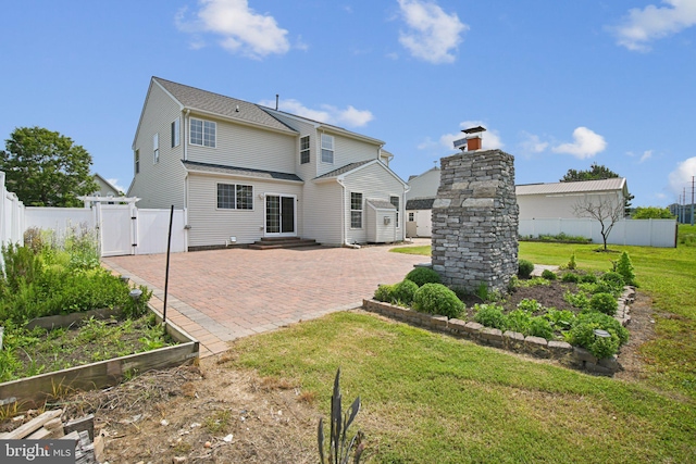 1624 Osprey Cir, Cambridge, MD 21613 - back of house featuring a gate, a vegetable garden, a patio area, and entry steps