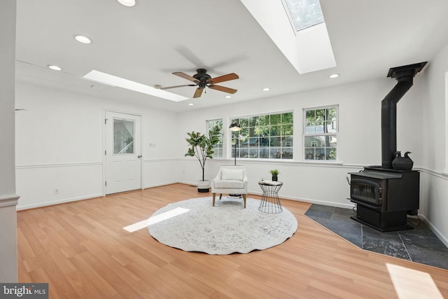 8408 Conover Pl, Alexandria, VA 22308 - living area with a skylight, a wood stove, wood finished floors, a ceiling fan, and recessed lighting