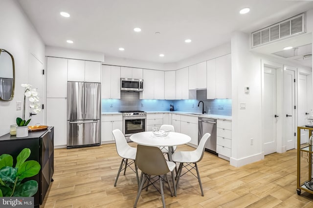 3514 13th St NW Unit 1, Washington, DC 20010 - kitchen featuring stainless steel appliances, light wood finished floors, backsplash, light countertops, and recessed lighting