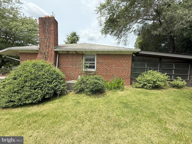 119 Cree Dr, Oxon Hill, MD 20745 - view of side of home featuring a yard, a chimney, brick siding, and cooling unit