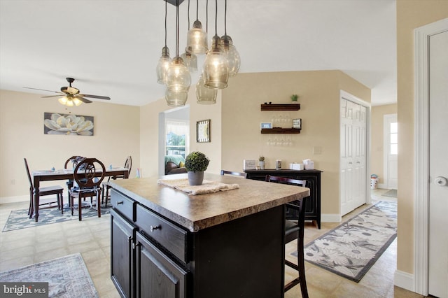 305 Old Stone Way, York, PA 17406 - kitchen with dark cabinets, a kitchen island, a ceiling fan, and plenty of natural light