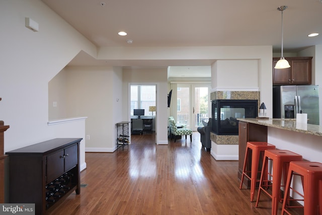 400 Blue Flax Pl, Gaithersburg, MD 20878 - kitchen featuring stainless steel refrigerator with ice dispenser, a kitchen bar, dark wood-style flooring, light stone counters, and recessed lighting