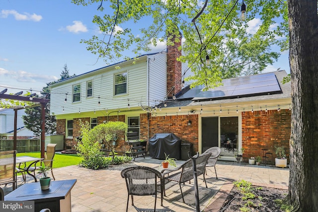 8600 Fox Run, Potomac, MD 20854 - back of property with solar panels, a patio, brick siding, and a pergola