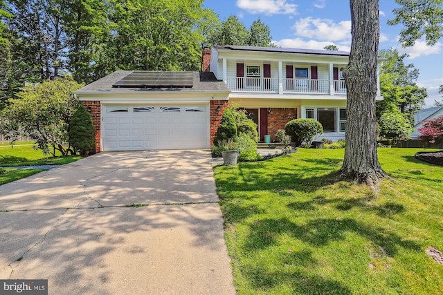 8600 Fox Run, Potomac, MD 20854 - view of front of property with brick siding, an attached garage, concrete driveway, solar panels, and a balcony