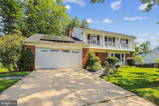8600 Fox Run, Potomac, MD 20854 - view of front of property featuring brick siding, an attached garage, a front yard, concrete driveway, and solar panels