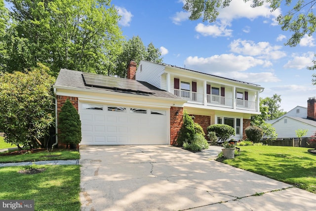 8600 Fox Run, Potomac, MD 20854 - view of front of property with brick siding, an attached garage, a front lawn, driveway, and solar panels
