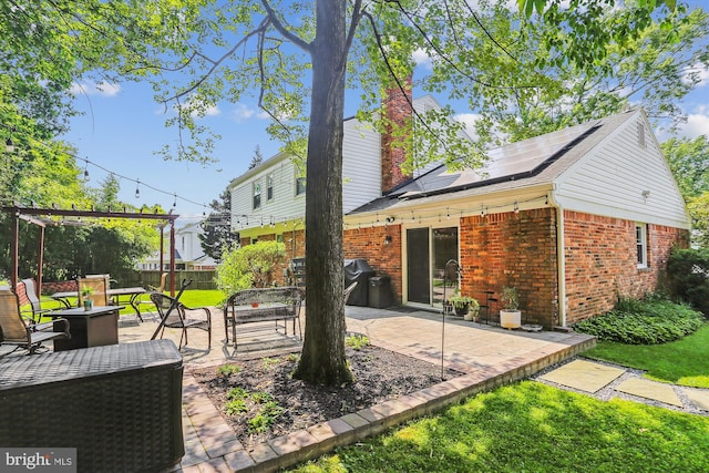 8600 Fox Run, Potomac, MD 20854 - back of house with brick siding, a patio area, solar panels, and a chimney