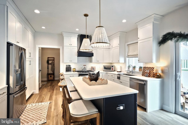 105 Fading Way, York, PA 17406 - kitchen with appliances with stainless steel finishes, custom exhaust hood, a center island, decorative backsplash, and white cabinets