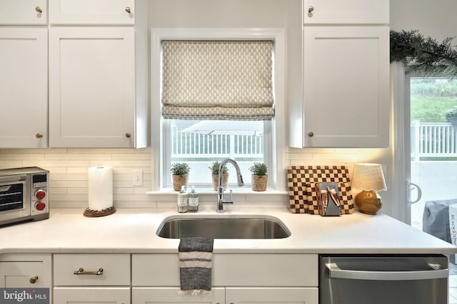 105 Fading Way, York, PA 17406 - kitchen with stainless steel dishwasher, white cabinetry, backsplash, and light countertops