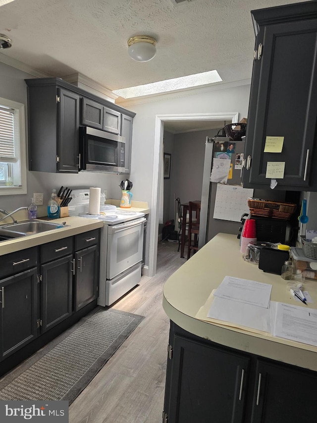 2800 Wakefield St, Colonial Beach, VA 22443 - kitchen featuring stainless steel microwave, white electric range, dark cabinetry, light wood finished floors, and crown molding