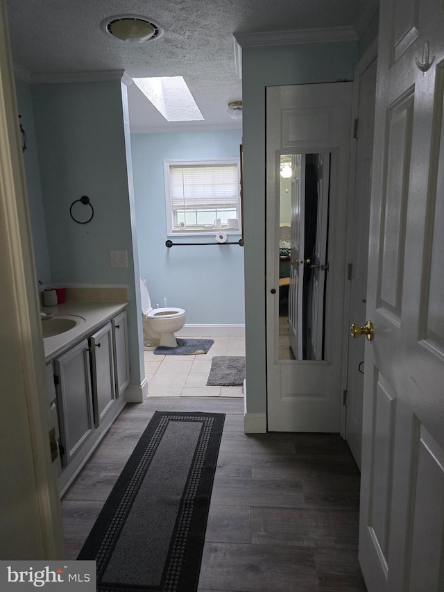2800 Wakefield St, Colonial Beach, VA 22443 - bathroom with a skylight, toilet, ornamental molding, baseboards, and vanity