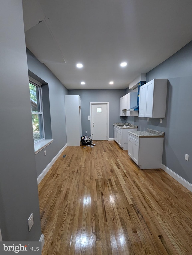 6323 Wheeler St, Philadelphia, PA 19142 - kitchen with light wood-style flooring, white cabinets, baseboards, recessed lighting, and light countertops