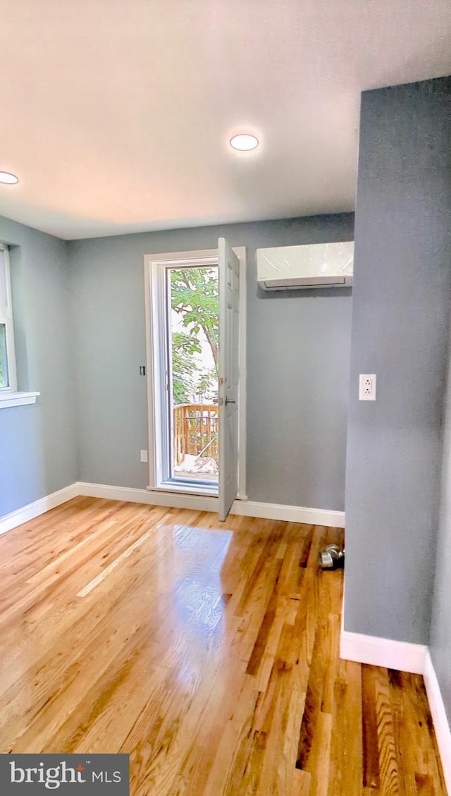 6323 Wheeler St, Philadelphia, PA 19142 - empty room featuring an AC wall unit, wood finished floors, baseboards, and recessed lighting