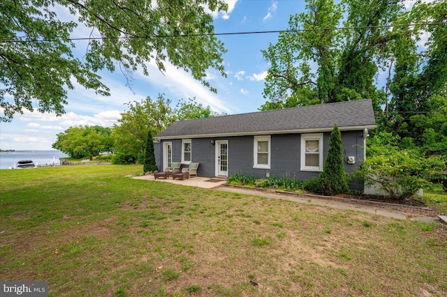 1312 Tuggies Rd, Pasadena, MD 21122 - single story home featuring a patio, a front yard, a water view, roof with shingles, and an outdoor living space