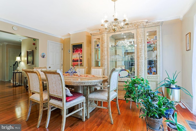 1027 Fredrick Blvd, Reading, PA 19605 - dining room with wood-type flooring, crown molding, and a chandelier