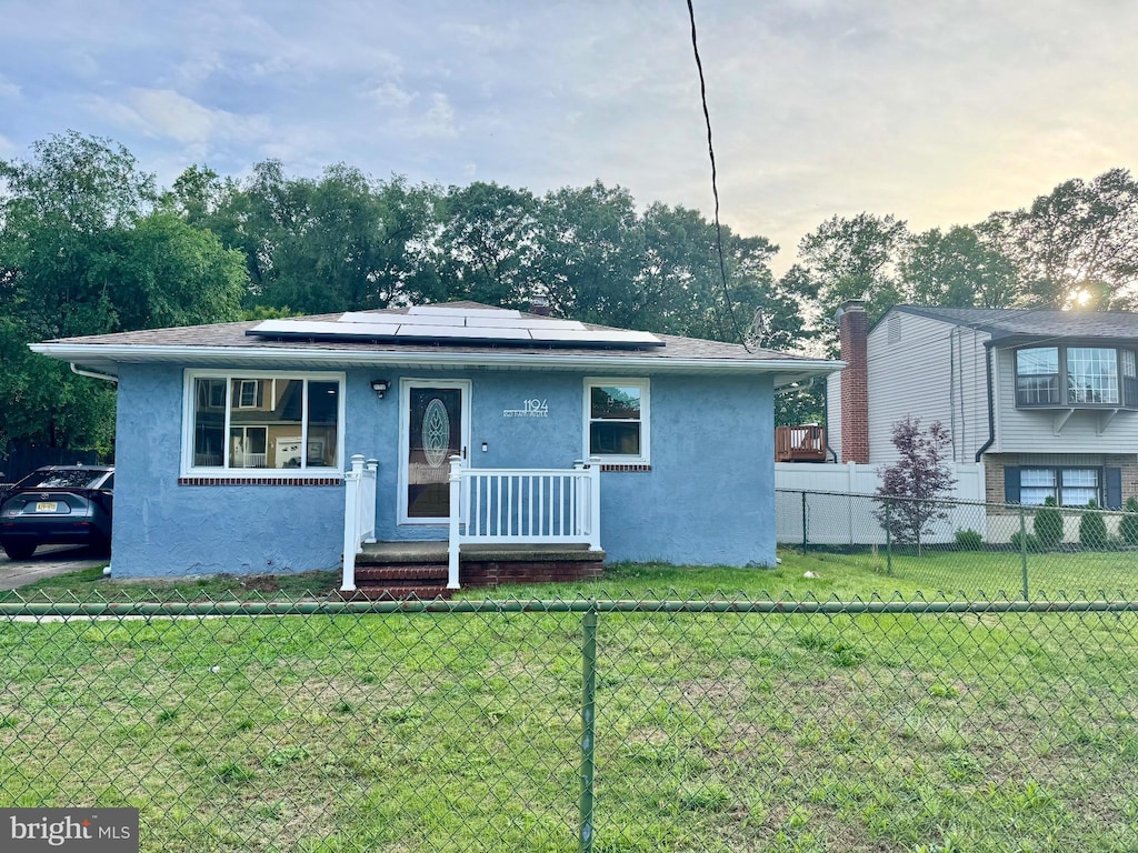 1194 Red Bank Ave, West Deptford, NJ 08086 - view of front of home featuring stucco siding and roof mounted solar panels