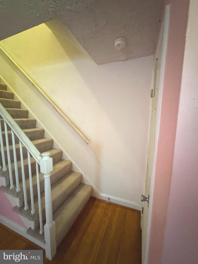 1525 Clairidge Rd, Baltimore, MD 21207 - staircase featuring wood finished floors and a textured ceiling