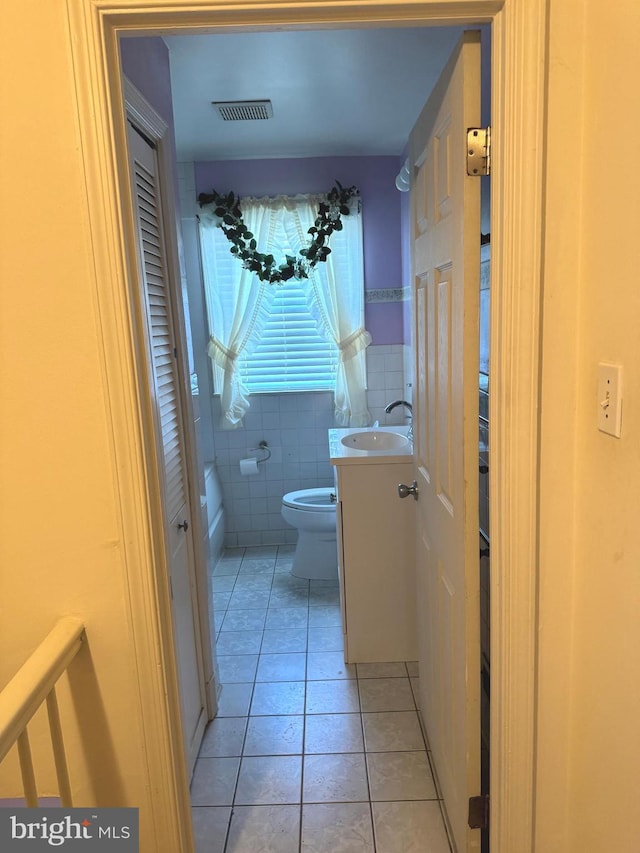 1525 Clairidge Rd, Baltimore, MD 21207 - bathroom with vanity, tile patterned floors, tile walls, and a closet