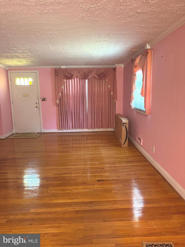 1525 Clairidge Rd, Baltimore, MD 21207 - unfurnished living room with a textured ceiling, crown molding, and wood-type flooring