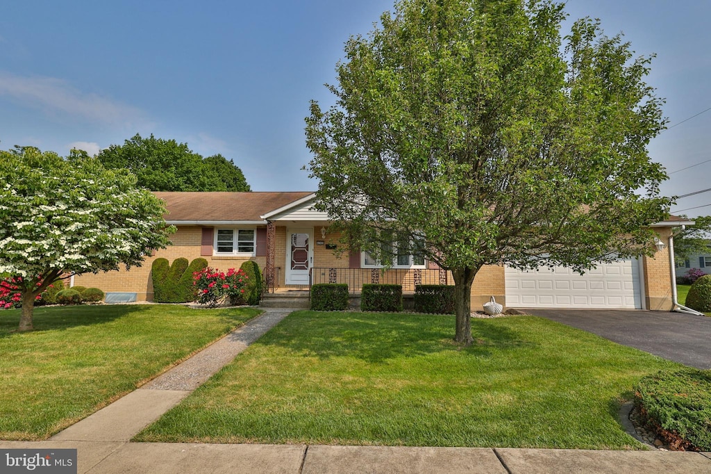 4385 Jay St, Whitehall, PA 18052 - view of front of house with driveway, a front yard, brick siding, and covered porch