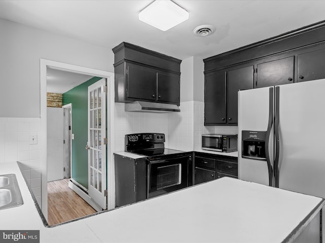 1002 Sherwood Cir, Salisbury, MD 21804 - kitchen featuring black range with electric stovetop, fridge with ice dispenser, dark cabinetry, under cabinet range hood, and light countertops