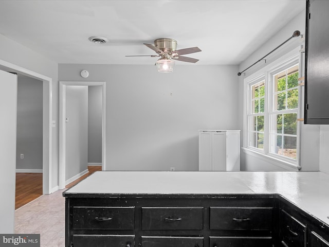 1002 Sherwood Cir, Salisbury, MD 21804 - kitchen with dark cabinetry, ceiling fan, light countertops, and a peninsula