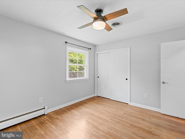 1002 Sherwood Cir, Salisbury, MD 21804 - unfurnished bedroom featuring baseboard heating, light wood-style flooring, a closet, and ceiling fan