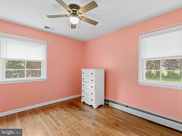 1002 Sherwood Cir, Salisbury, MD 21804 - unfurnished bedroom featuring a baseboard heating unit, wood finished floors, and a ceiling fan
