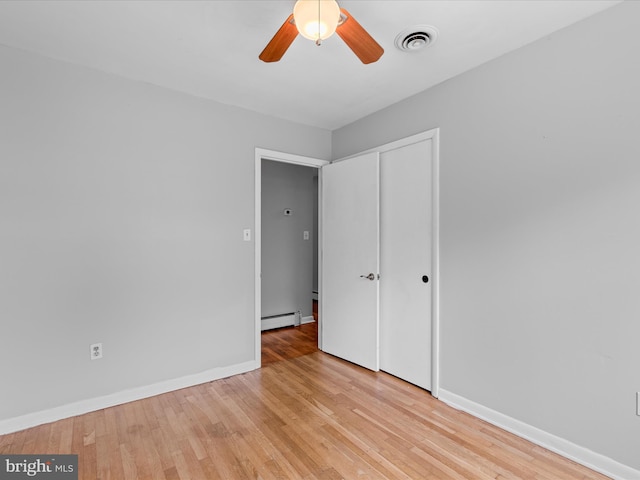 1002 Sherwood Cir, Salisbury, MD 21804 - unfurnished bedroom with baseboard heating, light wood-style floors, a closet, and a ceiling fan