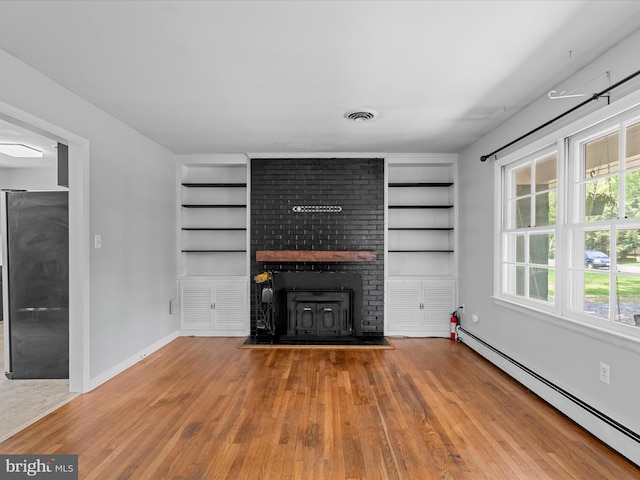 1002 Sherwood Cir, Salisbury, MD 21804 - unfurnished living room with a baseboard heating unit, built in shelves, a fireplace, and wood finished floors