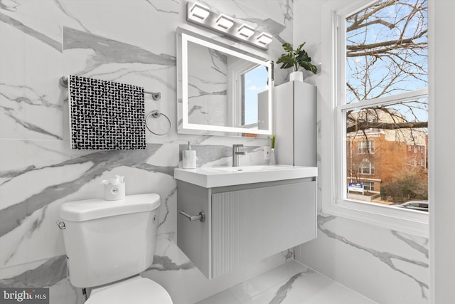 2923 Sherman Ave NW, Washington, DC 20001 - bathroom featuring marble look tile flooring, vanity, toilet, and healthy amount of natural light