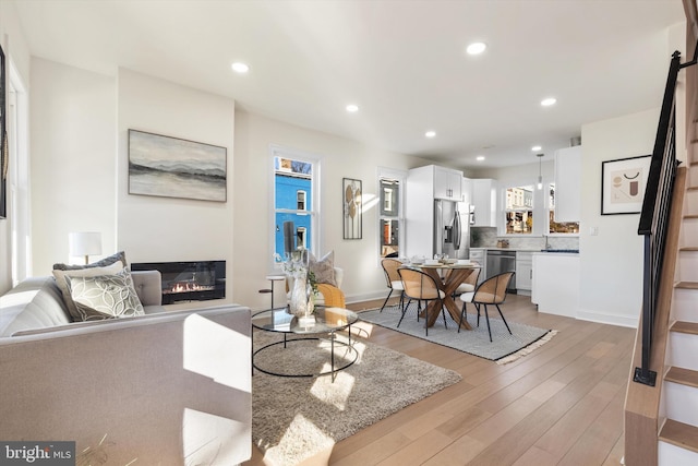 2923 Sherman Ave NW, Washington, DC 20001 - living area featuring a glass covered fireplace, light wood-style flooring, recessed lighting, and baseboards