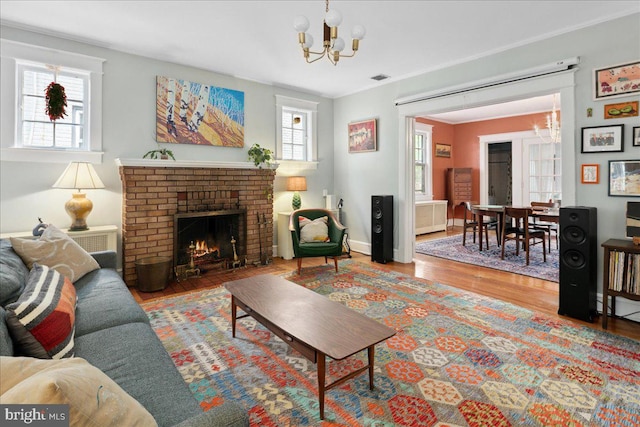 6721 Piney Branch Rd NW, Washington, DC 20012 - living area with a chandelier, wood finished floors, a fireplace, crown molding, and baseboards