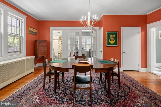 6721 Piney Branch Rd NW, Washington, DC 20012 - dining area featuring wood finished floors, radiator, a chandelier, ornamental molding, and baseboards