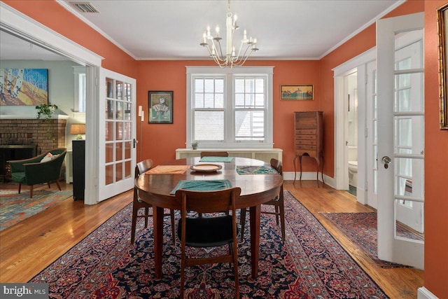 6721 Piney Branch Rd NW, Washington, DC 20012 - dining area featuring a chandelier, wood finished floors, french doors, and crown molding