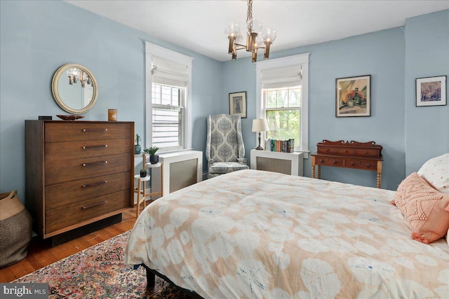 6721 Piney Branch Rd NW, Washington, DC 20012 - bedroom featuring a chandelier, multiple windows, and wood finished floors