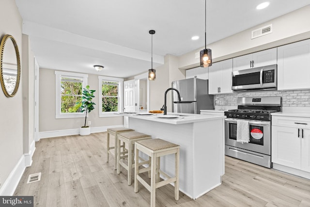 3414 Old York Rd, Baltimore, MD 21218 - kitchen featuring appliances with stainless steel finishes, a sink, light wood-type flooring, tasteful backsplash, and white cabinetry