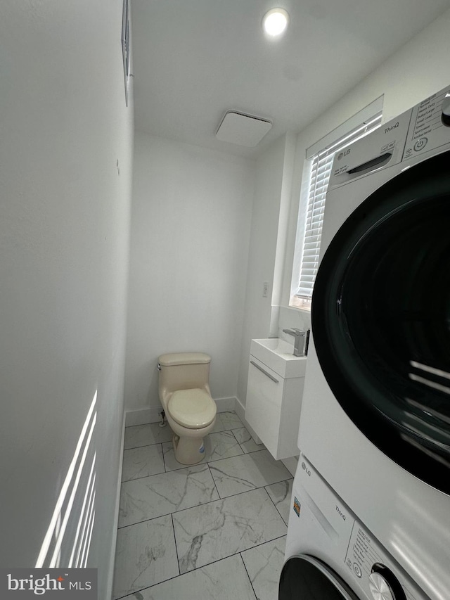 528 E Cheltenham Ave, Philadelphia, PA 19120 - washroom featuring stacked washer / drying machine, light marble finish floors, and baseboards