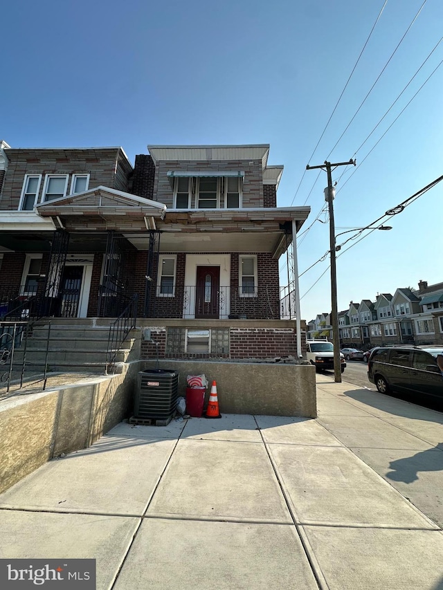 528 E Cheltenham Ave, Philadelphia, PA 19120 - view of property with brick siding, central air condition unit, and covered porch