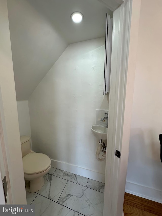 528 E Cheltenham Ave, Philadelphia, PA 19120 - bathroom with toilet, marble finish flooring, lofted ceiling, baseboards, and a sink