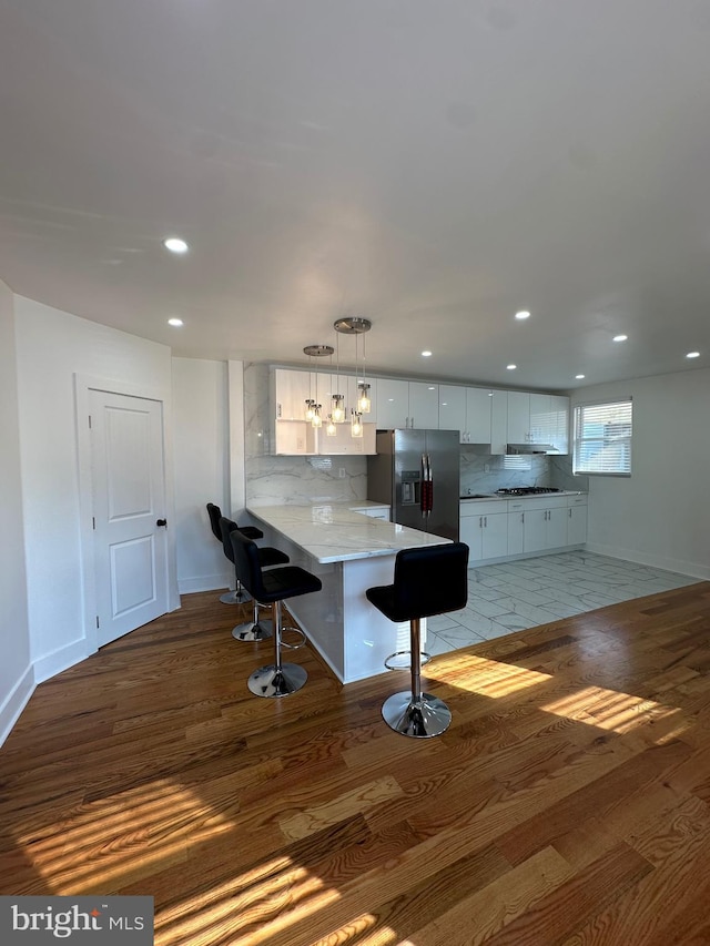 528 E Cheltenham Ave, Philadelphia, PA 19120 - kitchen featuring stainless steel refrigerator with ice dispenser, light wood-style floors, a peninsula, baseboards, and recessed lighting