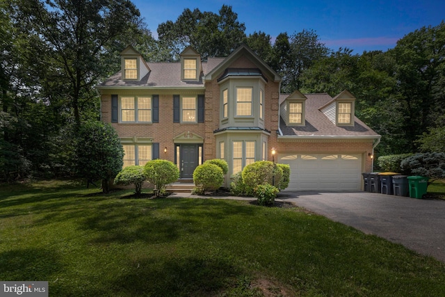11000 Hillgate Ln, Glenn Dale, MD 20769 - colonial inspired home with asphalt driveway, a lawn, brick siding, and an attached garage