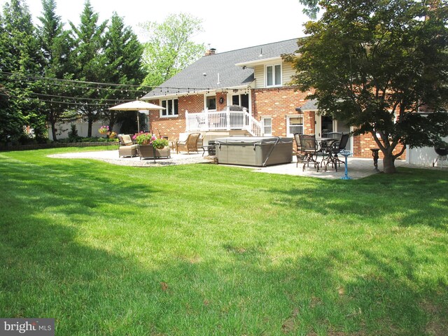 126 Devon Rd, Cinnaminson, NJ 08077 - back of property with a hot tub, a patio, brick siding, and a lawn