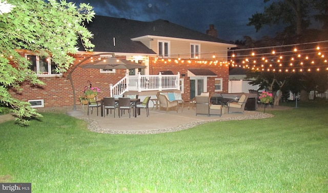126 Devon Rd, Cinnaminson, NJ 08077 - back of house at twilight featuring a patio, a lawn, and brick siding