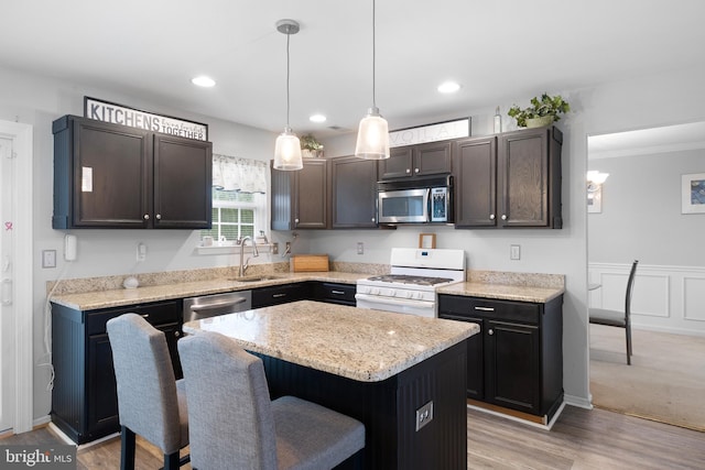 1 Brady Cir, Middletown, DE 19709 - kitchen with appliances with stainless steel finishes, a center island, a breakfast bar area, decorative light fixtures, and light stone counters