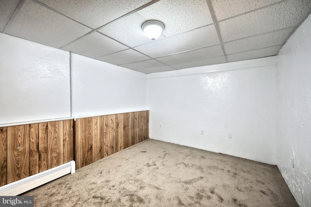 486 Highland Rd, Red Lion, PA 17356 - spare room featuring a baseboard radiator, carpet flooring, a paneled ceiling, wooden walls, and wainscoting