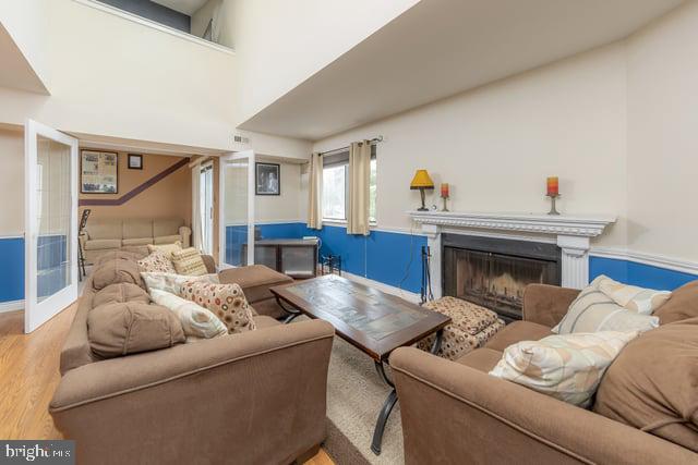 1004 Berwyck Ct, Sicklerville, NJ 08081 - living area featuring wood finished floors, a wainscoted wall, and a glass covered fireplace